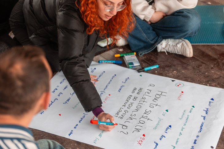 Fiatalok flipchart papírra írnak