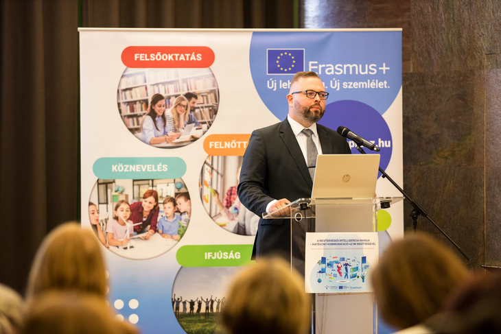 A mesterséges intelligencia hangja rendezvényen Bodrogi Richárd főigazgató tart beszédet egy pulpitus mögött állva