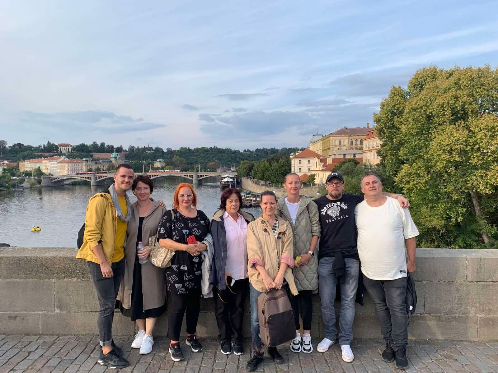 Emberek csoportja áll egy hídon Prágában