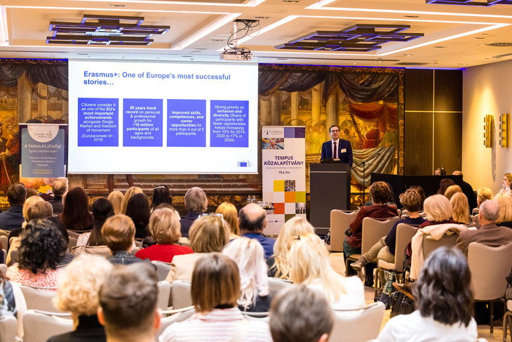 Elegáns férfi előadást az Erasmusplusz programról egy konferenciateremben