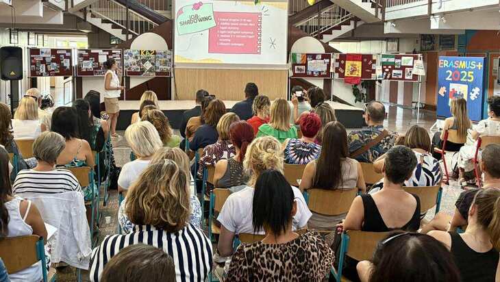 Előadás az Erasmusplusz programról egy iskolai aulában sok néző ül