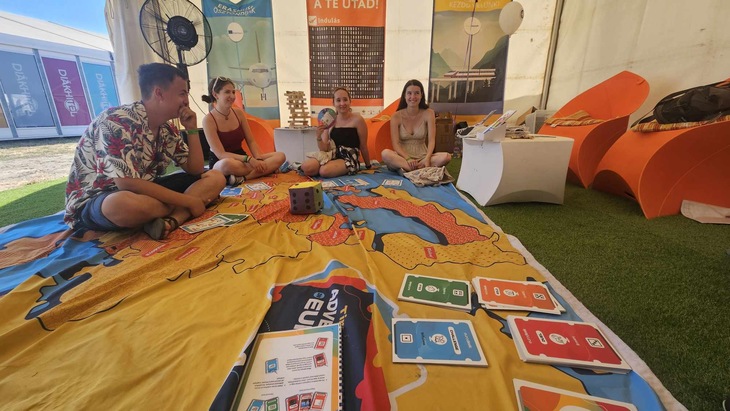fiatalok egy csoportja színes szőnyegen ülve beszélget az EFOTT fesztiválon