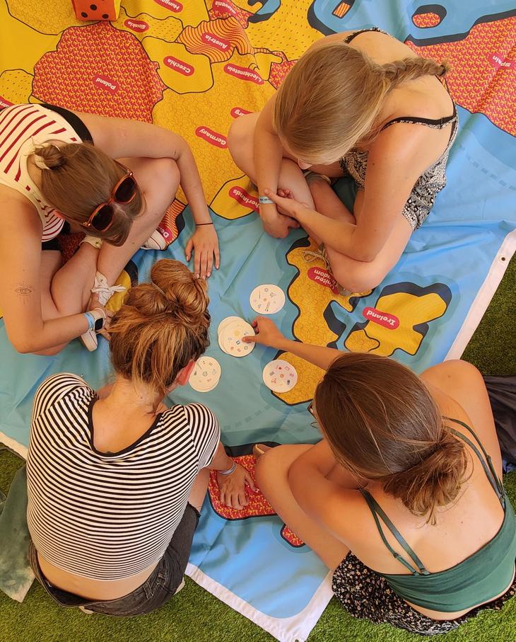 Négy fiatal lány színes szőnyegen ülve Dobble játékot játszik az EFOTTon