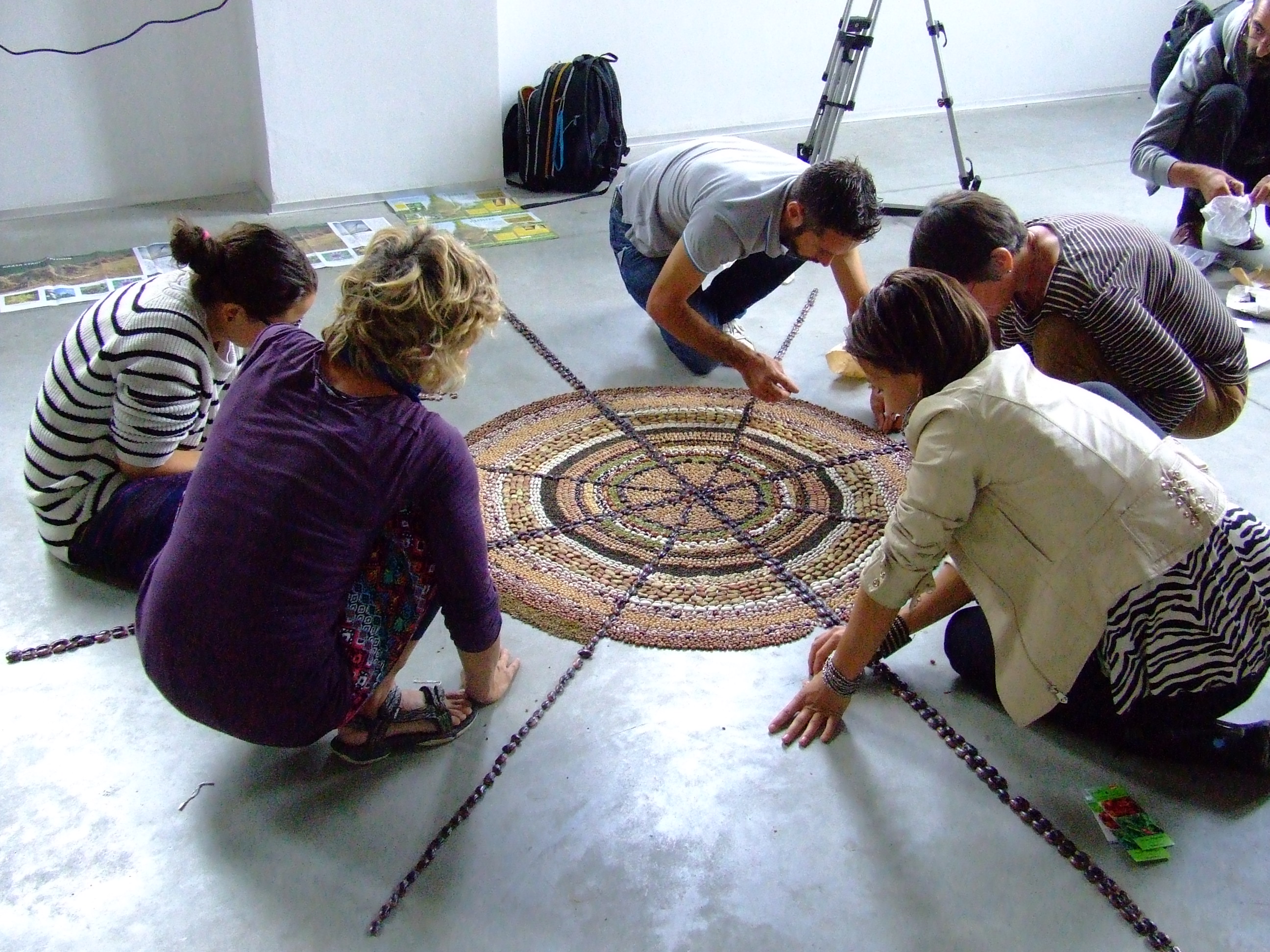 A Tudatos Vásárlók Egyesületének Erasmus Nívódíjas projektképén öten raknak a földre egy mandalát természetes anyagokból