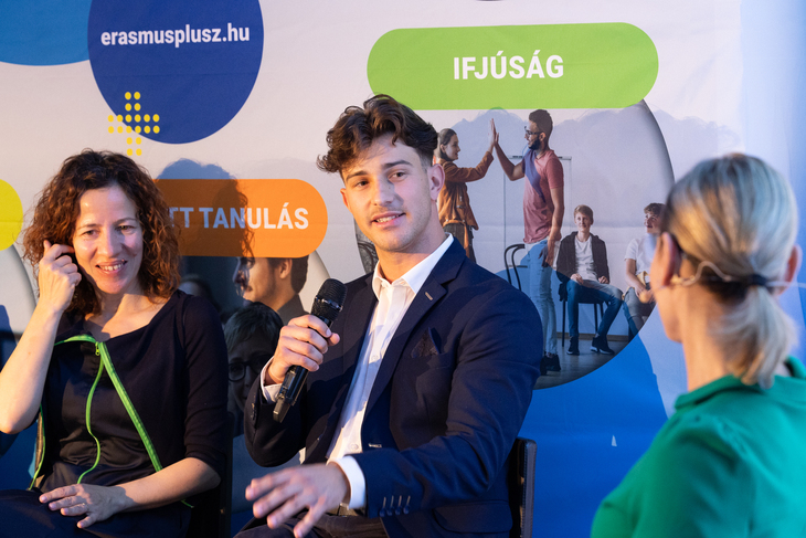 Erasmus Reloaded esemény képe az erasmusplusz plakát alatt ülő résztvevőkkel