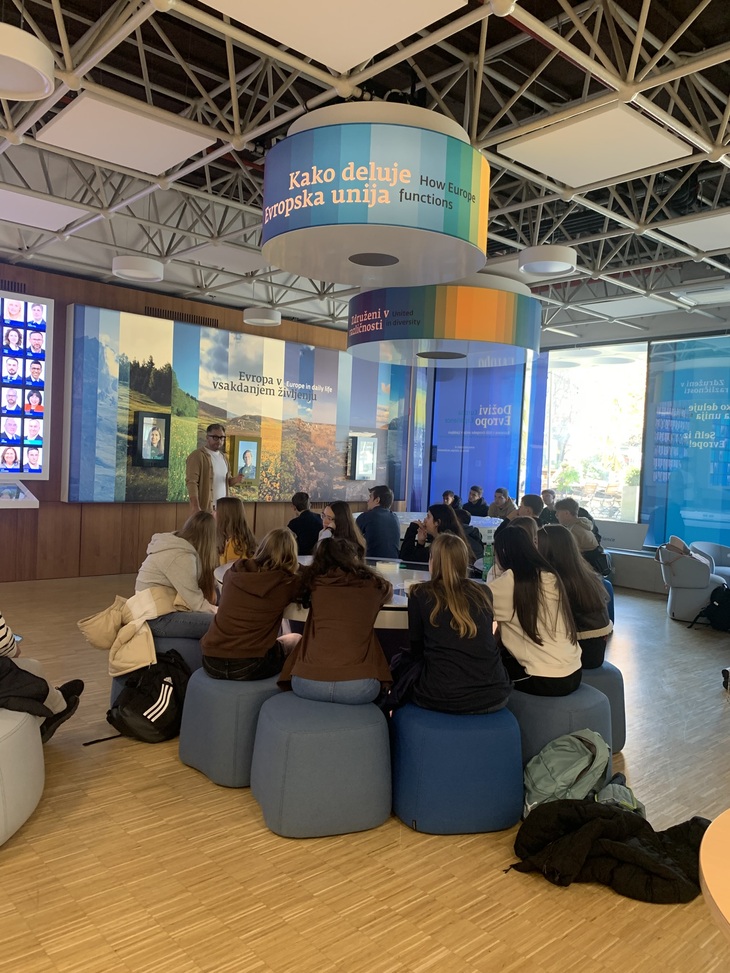 Di&aacute;kok k&eacute;k puffokon &uuml;lnek h&aacute;ttal sz&iacute;nes kivetőkkel teli fal előtt