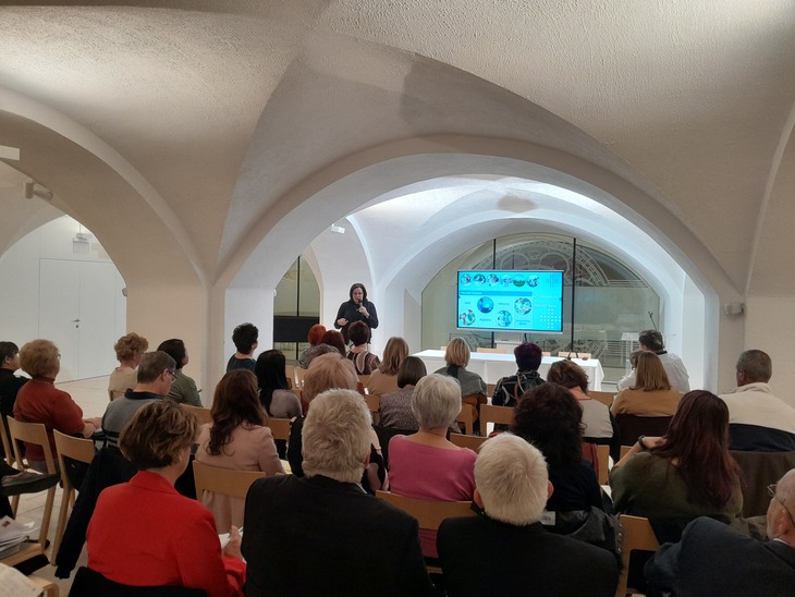 Farag&oacute; Kl&aacute;ra Erasmusplusz mentor előad&aacute;st tart egy bolt&iacute;ves teremben