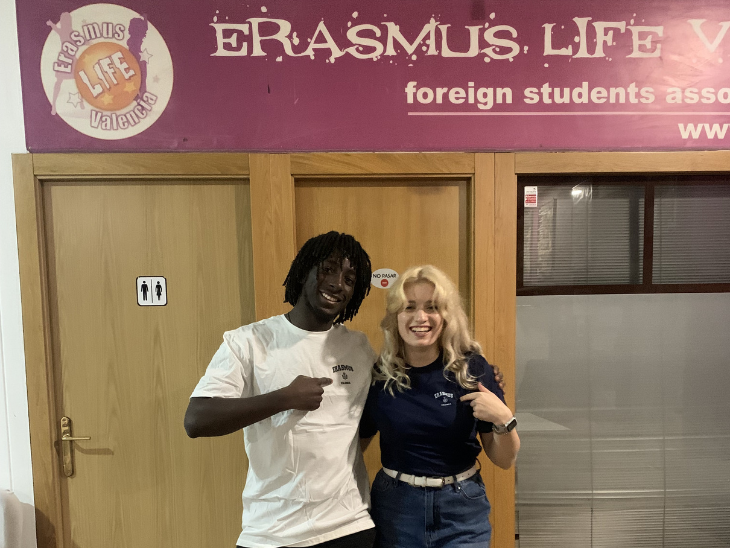 Fehér bőrű szőke lány és egy afroamerikai fiú egymást átölelve állnak egy ajtó előtt