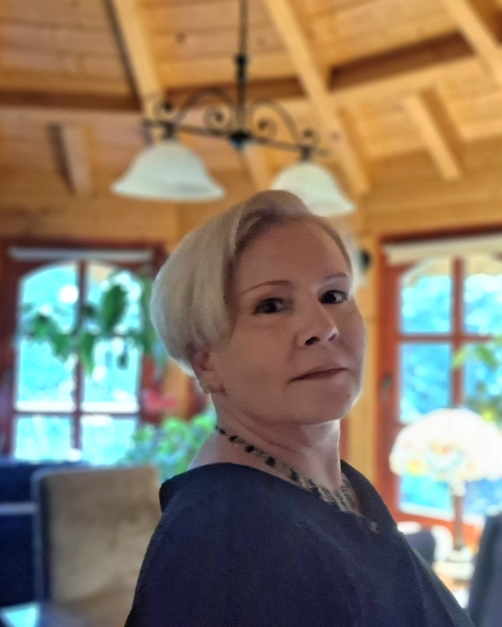 Szőke rövid hajú hölgy sötét felsőben