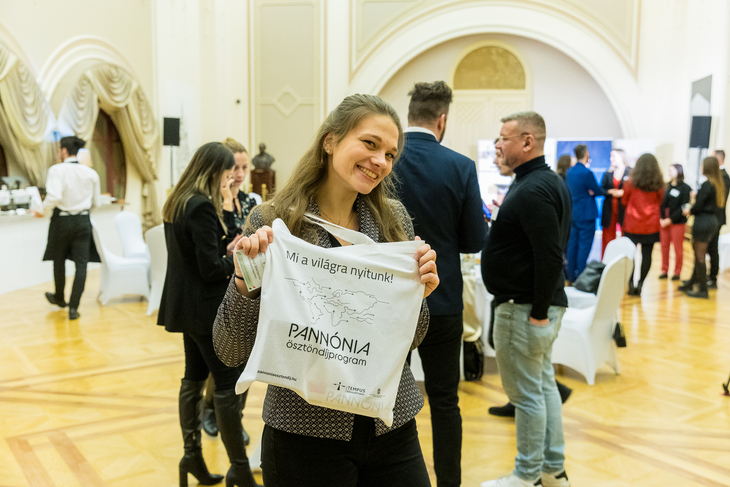 Végzős orvostanhallgató egy Pannónia Ösztöndíjprogram feliratú táskát tart fel