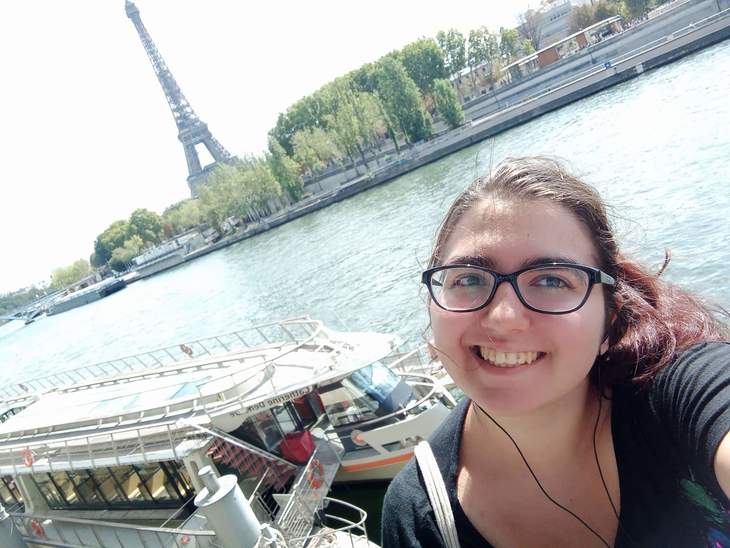 Fiatal lány háttérben az Eiffel toronnyal és a Szajna folyóval
