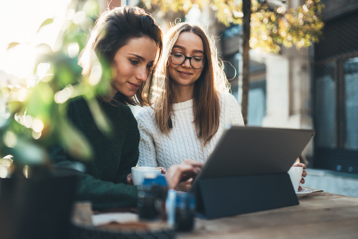 Két fiatal nő ül egy laptop előtt
