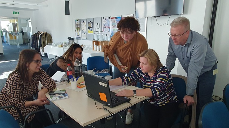 Csapatmunka a National VET Team akrreditált képzésén férfiak és nők egy asztalnál