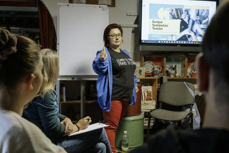 Ötletből változás workshopon az előadó magyaráz egy flipchart és egy kivetítő előtt