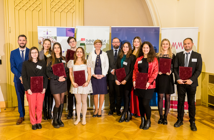 Egyetemista férfiak és nők elegáns ruhában egy díszvacsorán közös fotóra álltak össze