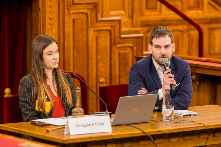 A Parlament üléstermében a pulpitus előtt ülve Hajdú András helyettes államtitkár válaszol a diákok kérdéseire