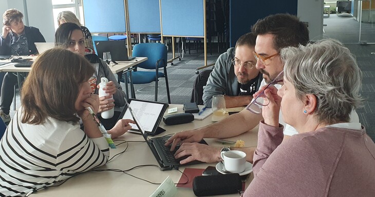 Projektoktatás workshop résztvevői beszélgetnek egy asztal körül