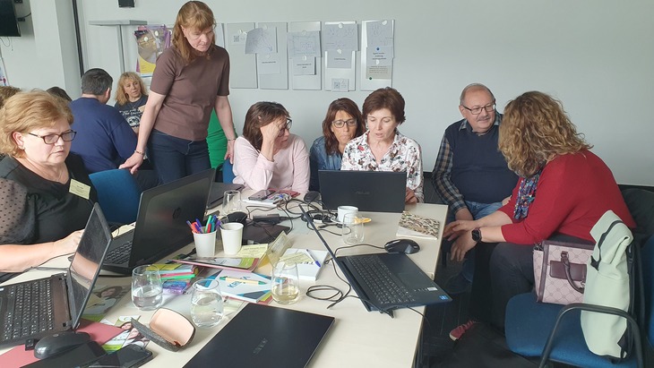 Projektoktatás workshop résztvevői csoportokba verődve dolgoznak külön asztaloknál