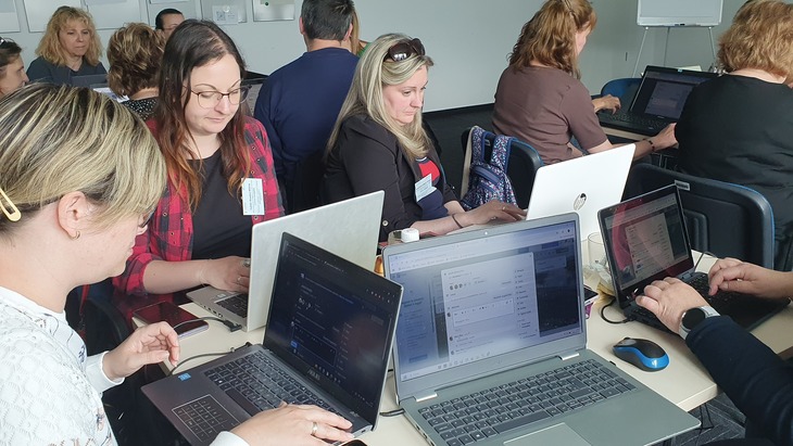 Projektoktatás workshop résztvevői kisebb csoportokban asztaloknál a laptojukon dolgozzák ki a feladatot