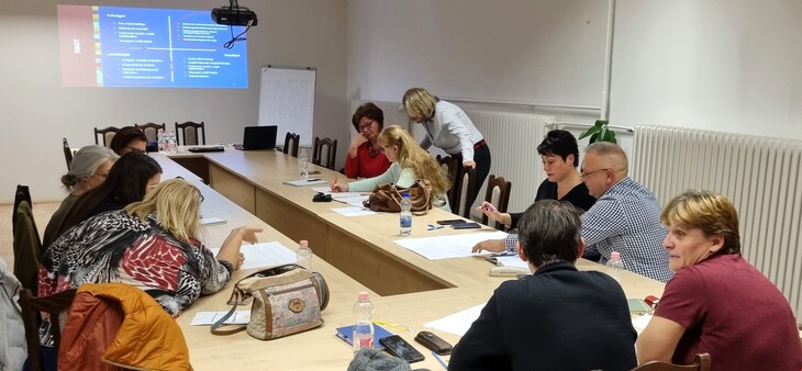 U alakú asztalnál férfiak és nők közösen dolgoznak