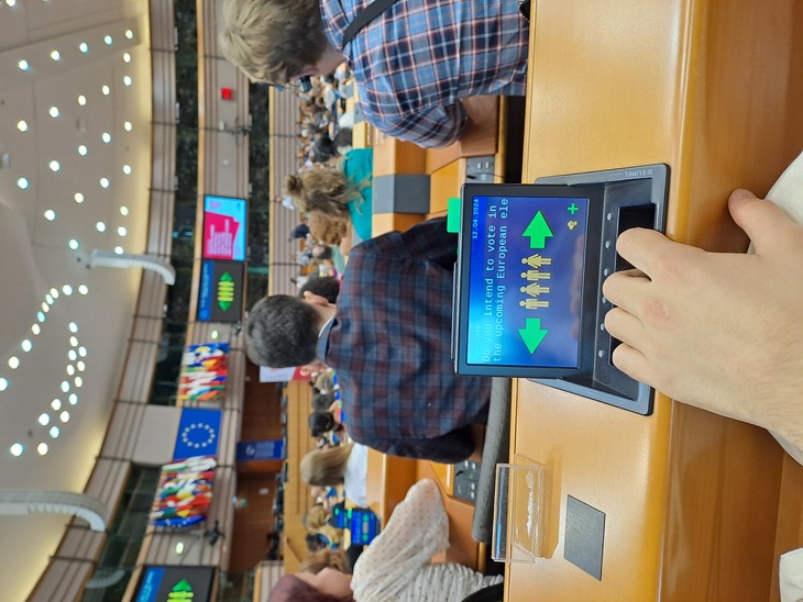 Az Európai Parlamentben egy fiatal használja a szavazópanelt