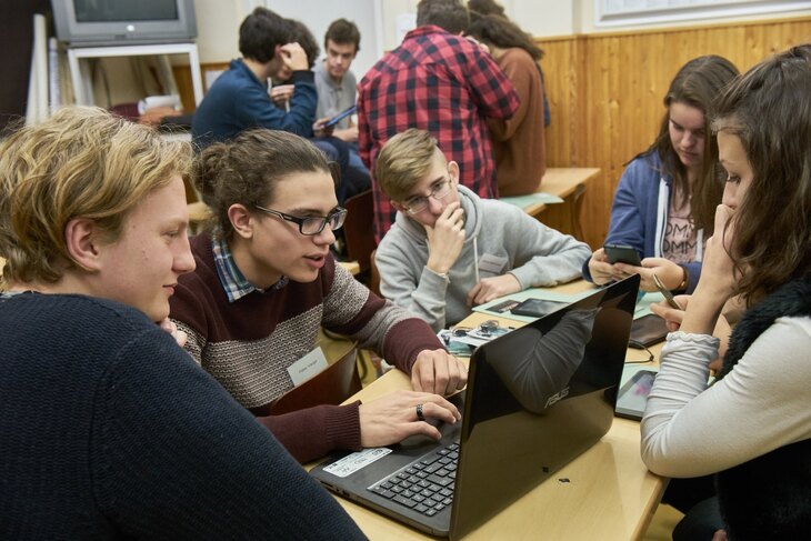 Diákok videóinterjúkat néznek egy laptop köré ülve